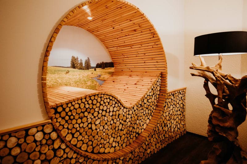Niche ronde en bois avec rondins empilés et vue sur le paysage naturel dans l'espace bien-être